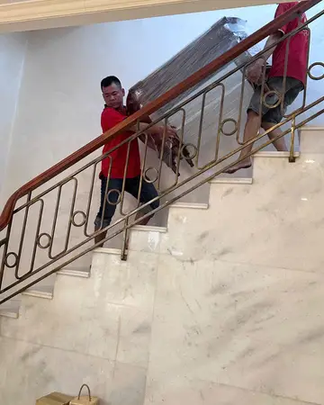 Nhân viên Thành Hưng đưa đồ cồng kềnh qua cầu thang trong nhà